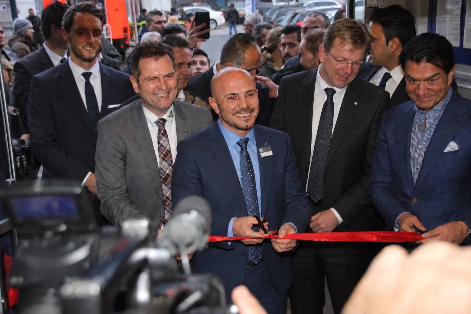 Erdal Öztürk beim Durchschneiden des roten Bandes zur Eröffnung eines Automotive-Standorts in Hamburg im Jahr 2016